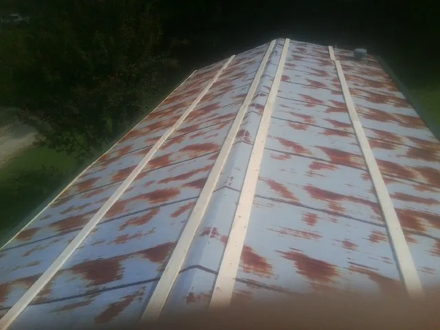 Rusted metal roof panels with new wood purlins before replacement — Storm Damage Roof Repair in Boswell by Roofing Brothers